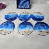 Unique beach-inspired wooden coasters with resin waves and sand