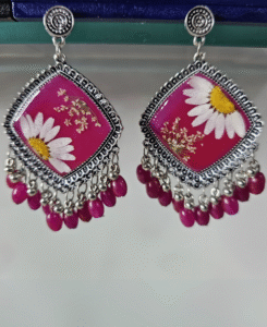 Pink resin earrings featuring daisies and purple bead detailing