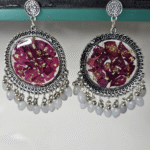 Purple resin earrings with floral petals and gold flakes.