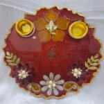 Maroon pooja thali with golden Ganesh and diya holders