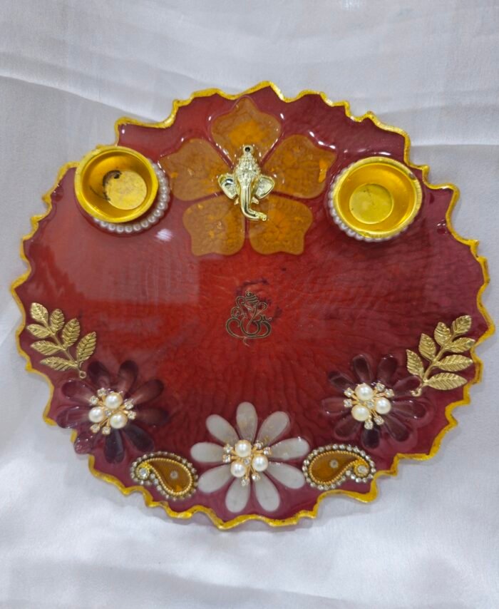 Maroon pooja thali with golden Ganesh and diya holders