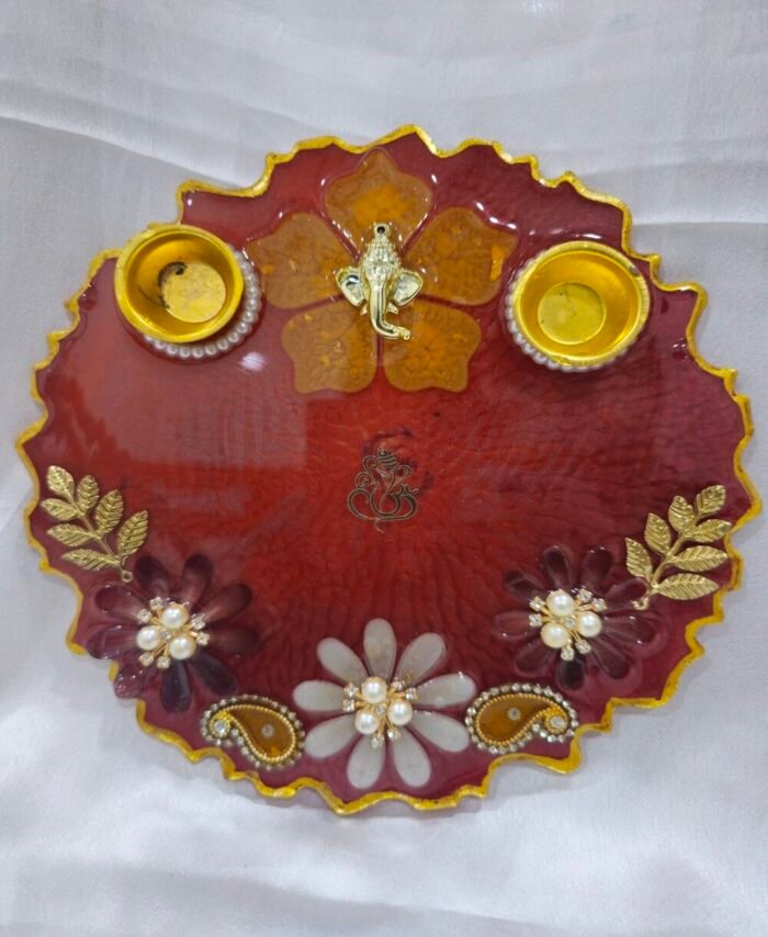 Maroon pooja thali with golden Ganesh and diya holders