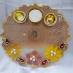 Beige floral pooja thali with yellow and pink decorations