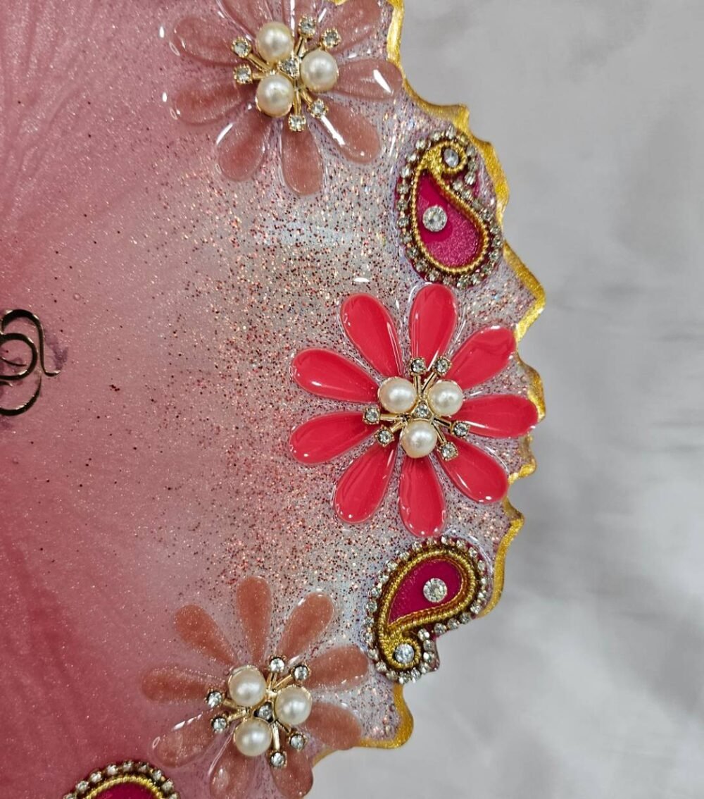 Pink resin pooja plate with pearl and paisley design