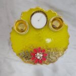 Yellow resin pooja thali with floral decoration and diya holders