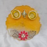 Orange resin pooja thali with Ganesha and diya holders