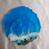 Artistic ocean-inspired resin coaster with golden shimmer