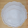 "Three silicone wavy-edge cake stand moulds in different sizes placed on a wooden surface"