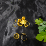 Gold-plated round ring bezels for resin art on black background Adjustable resin jewellery ring bezels in golden colour DIY resin art empty ring bases gold finish