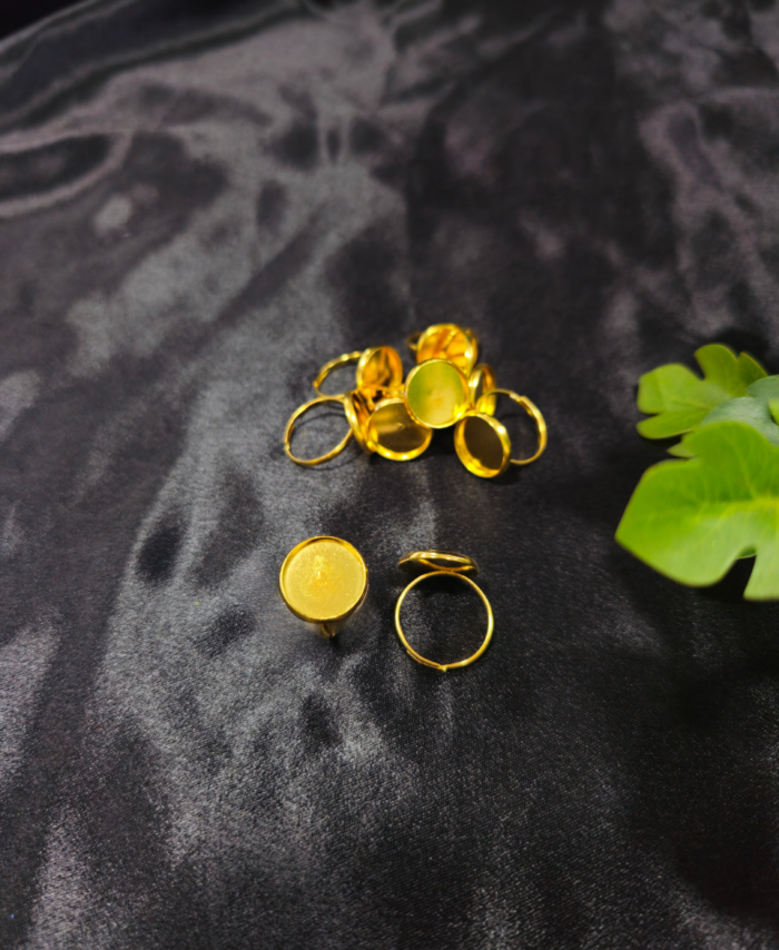 Gold-plated round ring bezels for resin art on black background Adjustable resin jewellery ring bezels in golden colour DIY resin art empty ring bases gold finish