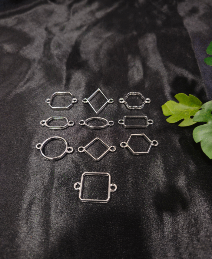 Silver-plated assorted resin bezels in multiple shapes are displayed on a black background. Mixed-shape silver bezels with double hooks arranged neatly for resin jewellery making.