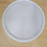 Round smooth-edge silicone mold for resin art placed on a wooden surface, ideal for making resin trays and coasters.