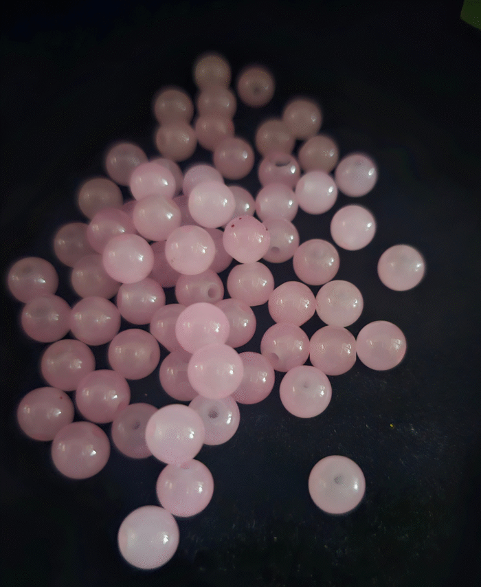 Clear faceted crystals are scattered on black fabric, with a green leaf visible in the corner.