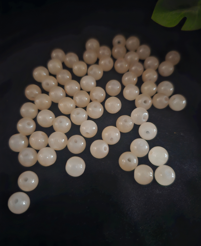 Clear faceted crystals are scattered on black fabric, with a green leaf visible in the corner.