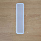 Three transparent silicone bookmark moulds in small, medium, and large sizes on a wooden surface 3-in-1 bookmark mould set with hole for tassels