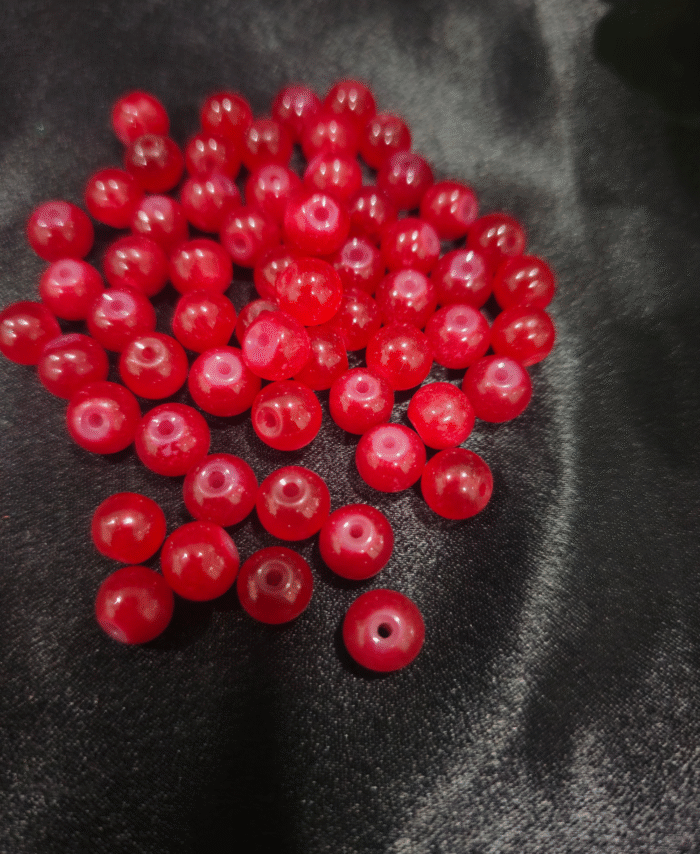 Clear faceted crystals are scattered on black fabric, with a green leaf visible in the corner.