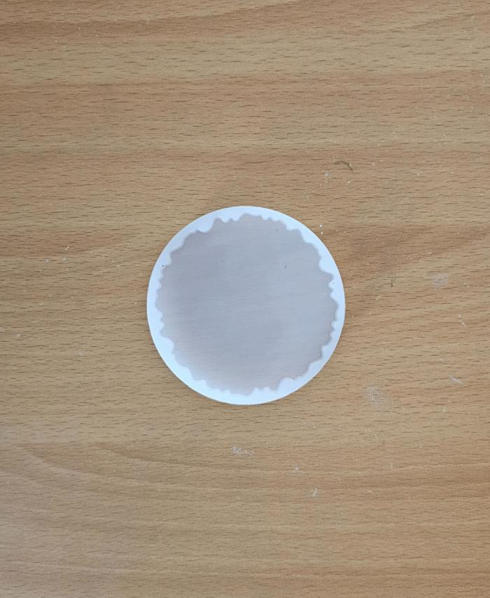 3-inch round agate silicone mould with wavy edge placed on a wooden surface