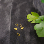 Small gold-plated cord end caps displayed on a black background. Jewellery cord end caps are used for finishing bracelets, keychains, and craft cords.