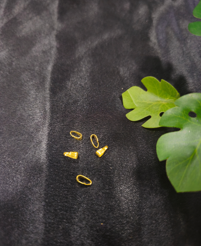 Small gold-plated cord end caps displayed on a black background. Jewellery cord end caps are used for finishing bracelets, keychains, and craft cords.