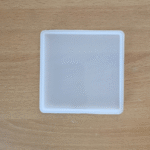 4-inch square silicone mould for resin casting placed on a wooden background.