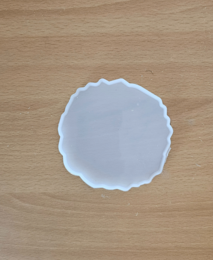 4-inch round agate silicone mould for resin casting placed on a wooden surface.