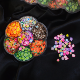 Flower-shaped wheel filled with colourful Fimo fruit and decorative clay slices for resin and art.