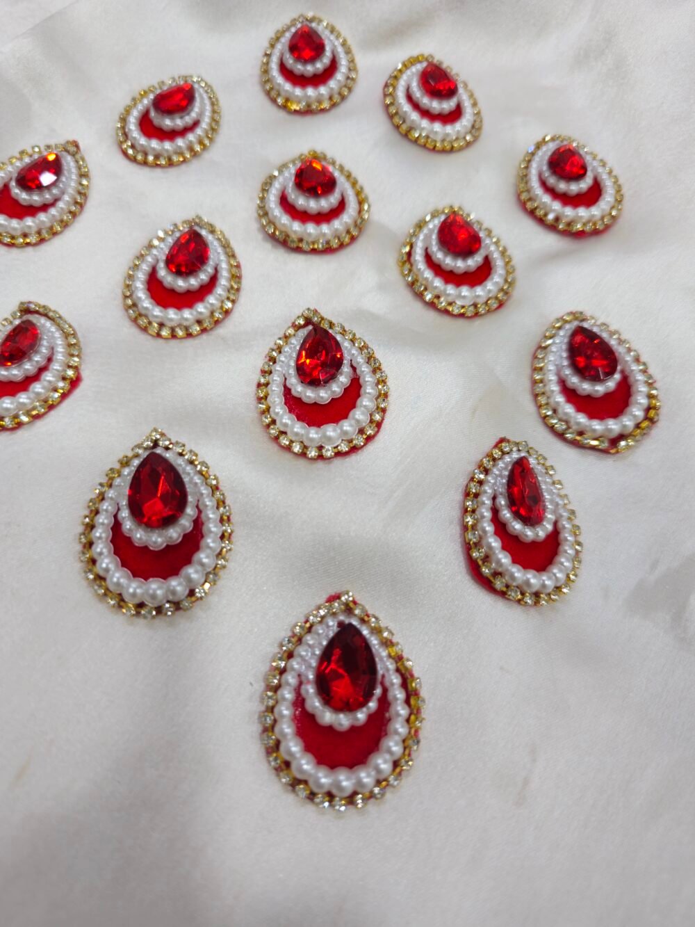 Red teardrop pearl and crystal embellishment charms with golden rhinestone border for DIY crafts and resin art.