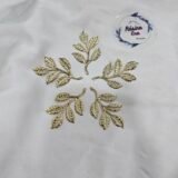 Gold metal leaf branch charm with detailed textured leaves placed on a white background.