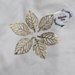 Gold filigree leaf metal charms arranged in a circular pattern on a white background.