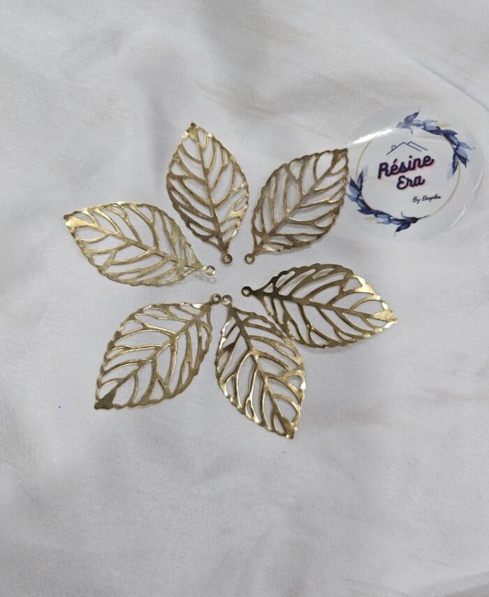 Gold filigree leaf metal charms arranged in a circular pattern on a white background.