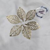 Gold filigree leaf metal charms arranged in a circular pattern on a white background.