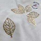 Gold filigree leaf metal charms arranged in a circular pattern on a white background.
