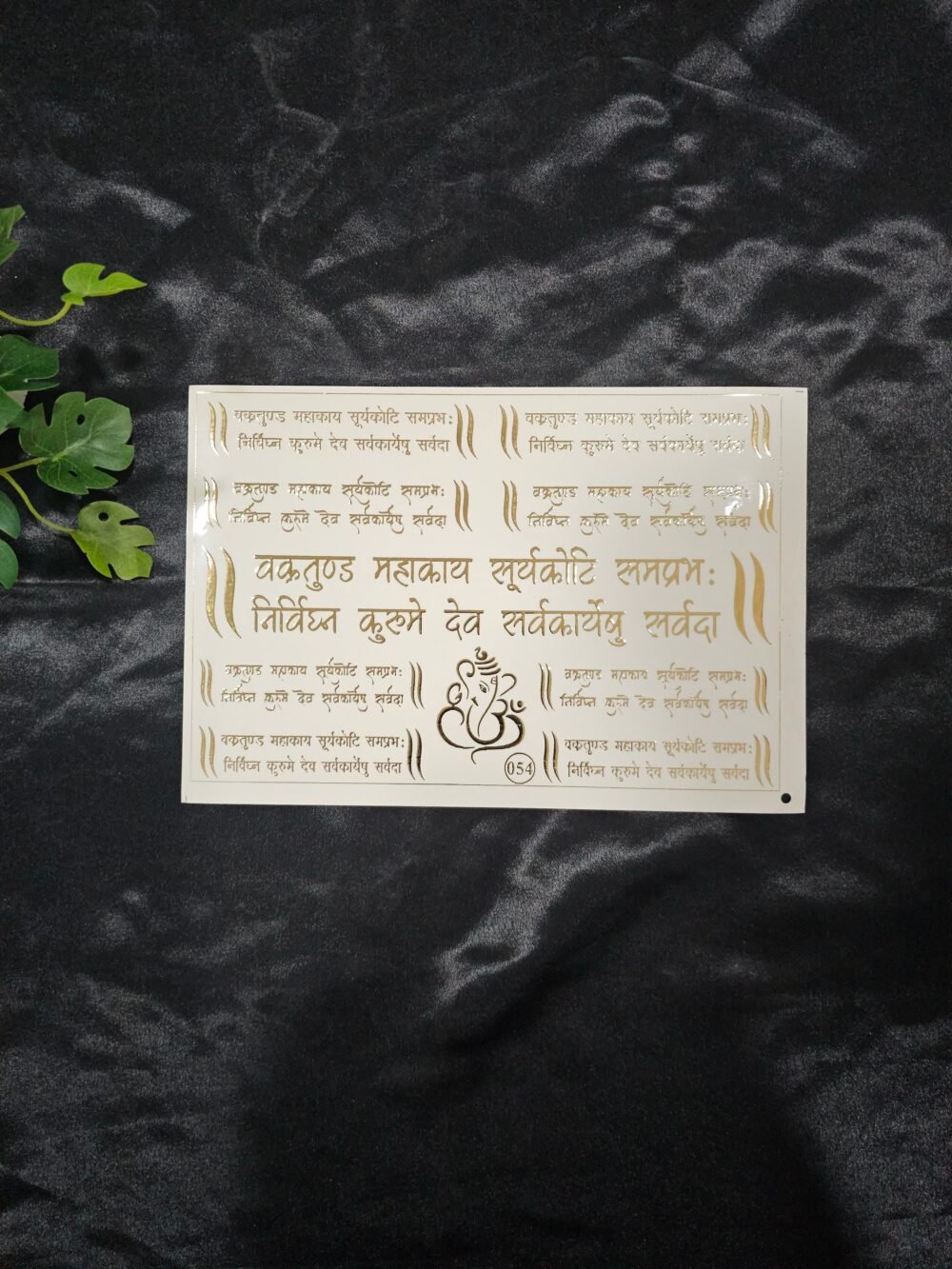 Gold embossed Vakratunda Mahakaya mantra sticker sheet with Sanskrit text and Ganesha symbol on a white background.