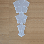“Four-cavity silicone flower mould with different flower sizes placed on a wooden surface.”