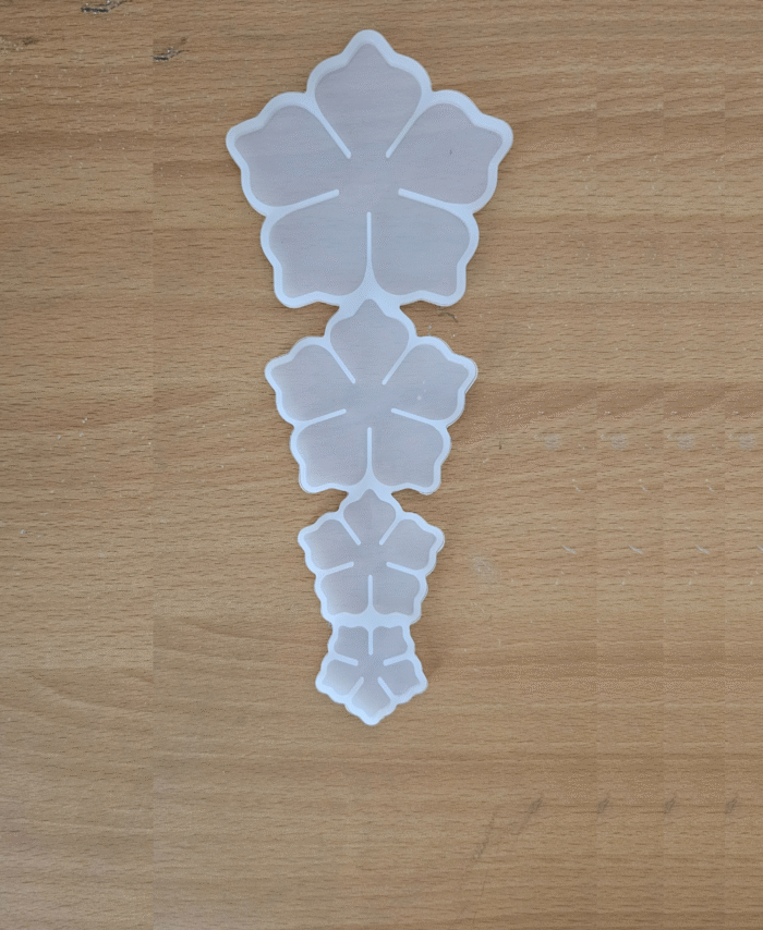 “Four-cavity silicone flower mould with different flower sizes placed on a wooden surface.”
