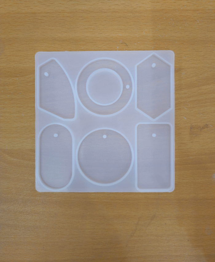 Silicone mould with multiple bag tag shapes, including round, oval, rectangle, and hexagon cavities