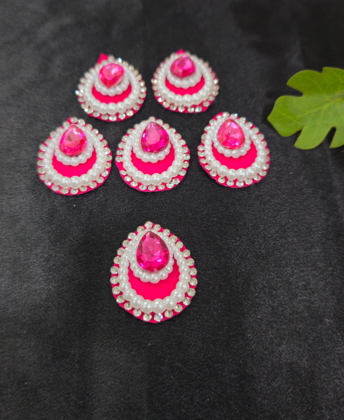 teardrop kundan embellishments with pearl and crystal border on a black background