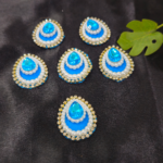 teardrop kundan embellishments with pearl and crystal border on a black background