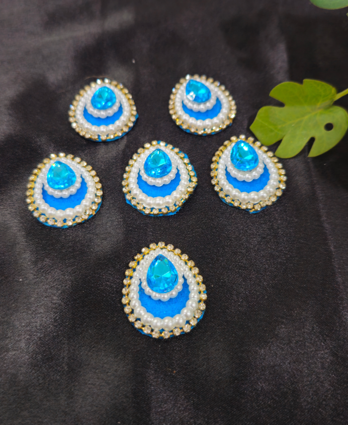 teardrop kundan embellishments with pearl and crystal border on a black background