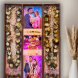 3-column full varmala preservation frame with preserved wedding garland flowers, couple photos, pearls, and decorative elements set in epoxy resin wooden wall frame.