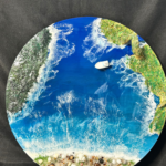 Round ocean resin wall art with blue waves, sandy beach texture, and glossy finish