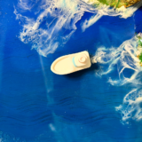 Round ocean resin wall art with blue waves, sandy beach texture, and glossy finish