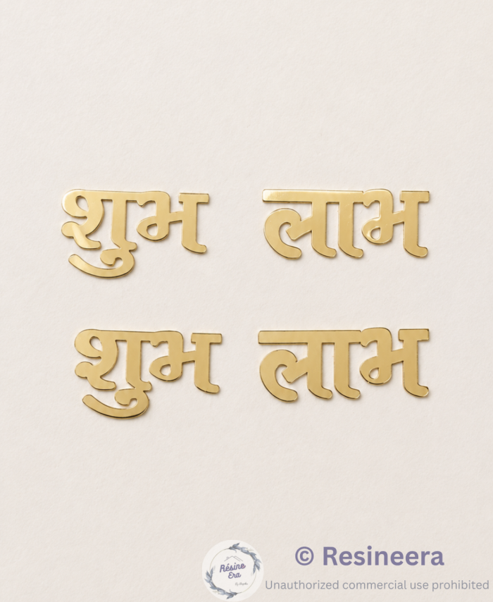 Golden acrylic Subha Labh Hindi words placed on shiny blue fabric background.