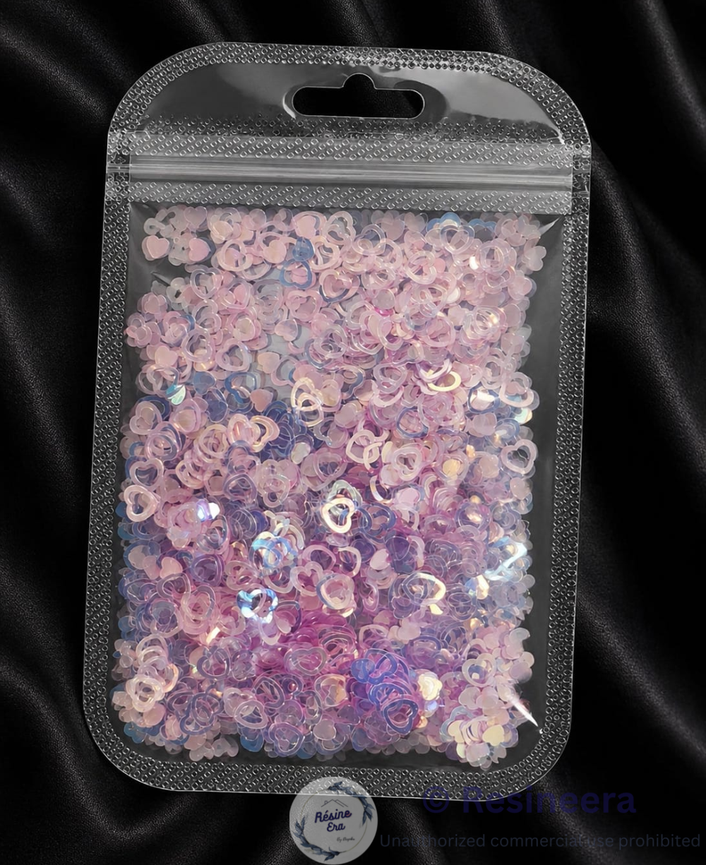 Heart Pink Holographic/Sequence Heart glitter flakes for resin art and craft decoration on a dark background