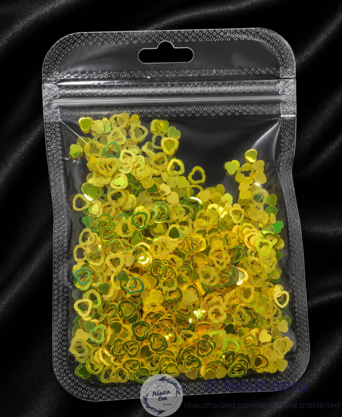 Holographic/Sequence Heart glitter flakes for resin art and craft decoration on a dark background