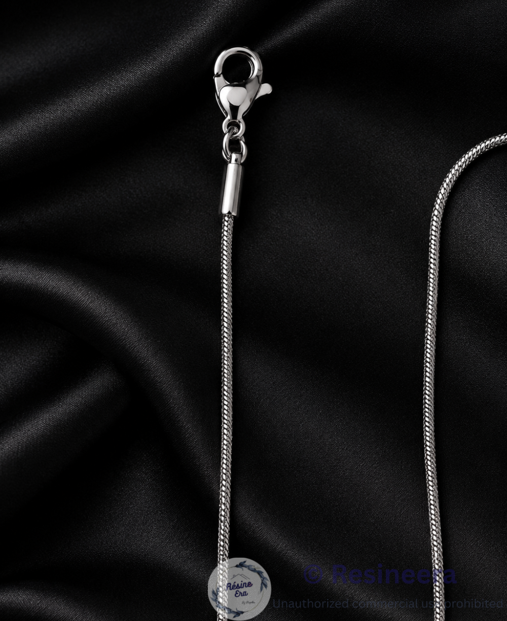 Silver anti-tarnish chain necklace with lobster clasp and extension chain on a beige background.