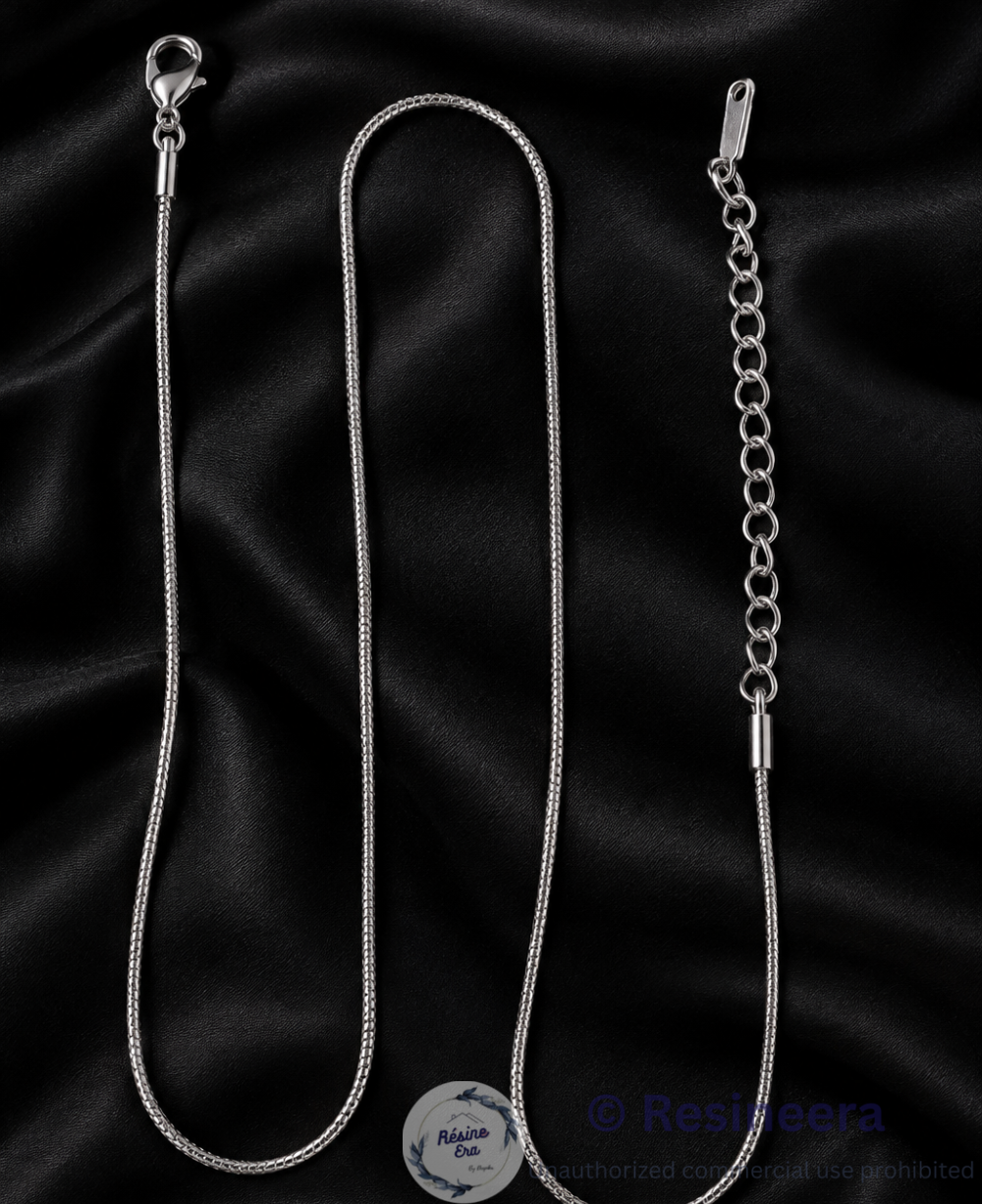 13 Silver anti-tarnish chain necklace with lobster clasp and extension chain on a beige background.